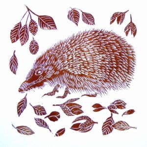 An unframed lino print in brown of a hedgehog surrounded by beech leaves and falling nuts